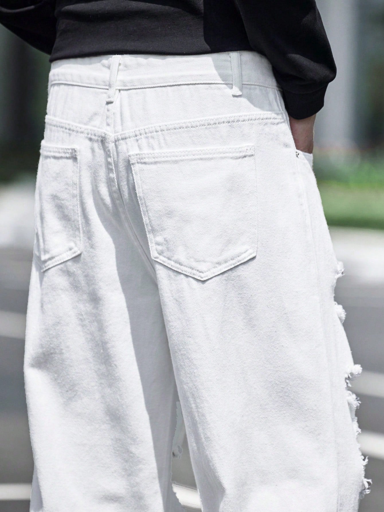 Men’s white ripped wide-leg jeans with heavy distressing and streetwear fit