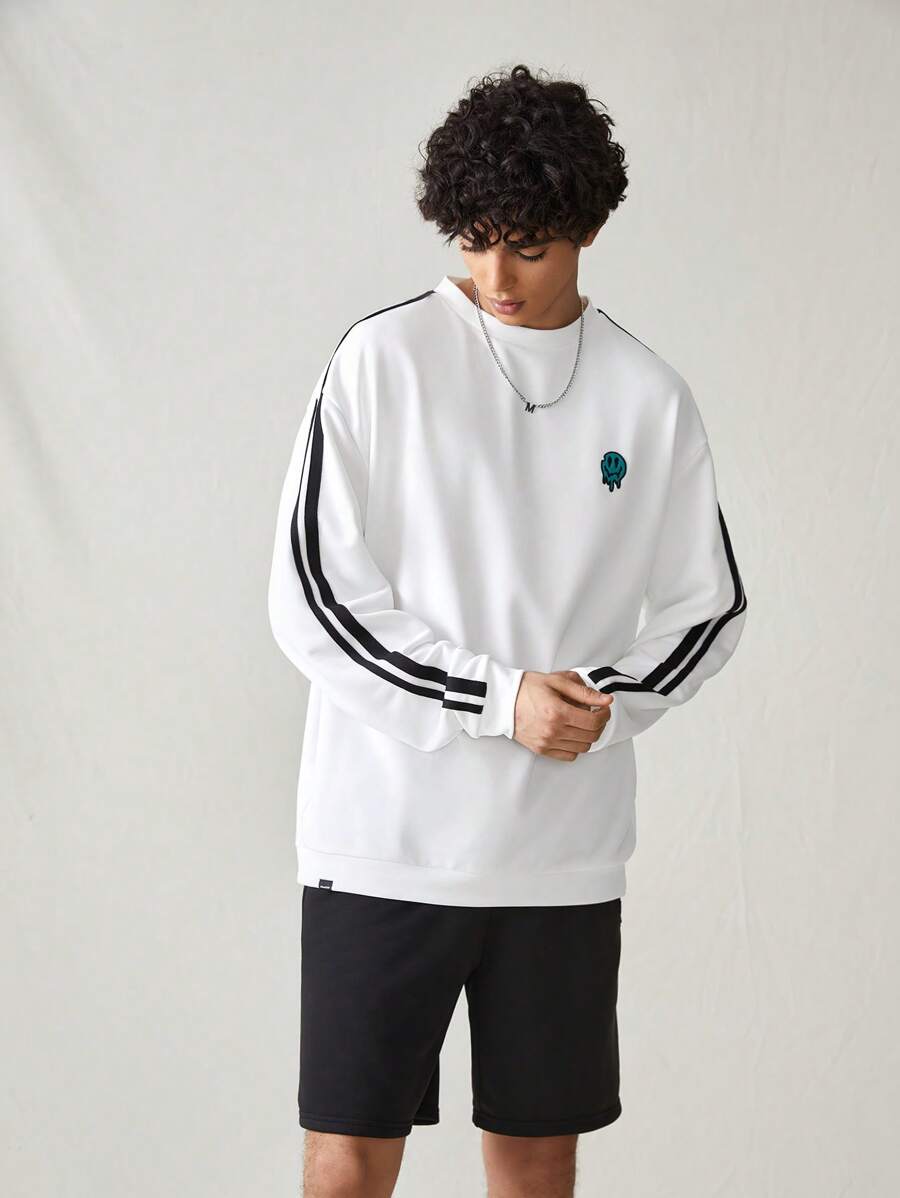 Japanese streetwear white pullover sweatshirt with black side stripes, loose fit, and embroidered chest detail