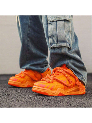 Chunky orange sneakers with thick rope laces, futuristic streetwear platform shoes