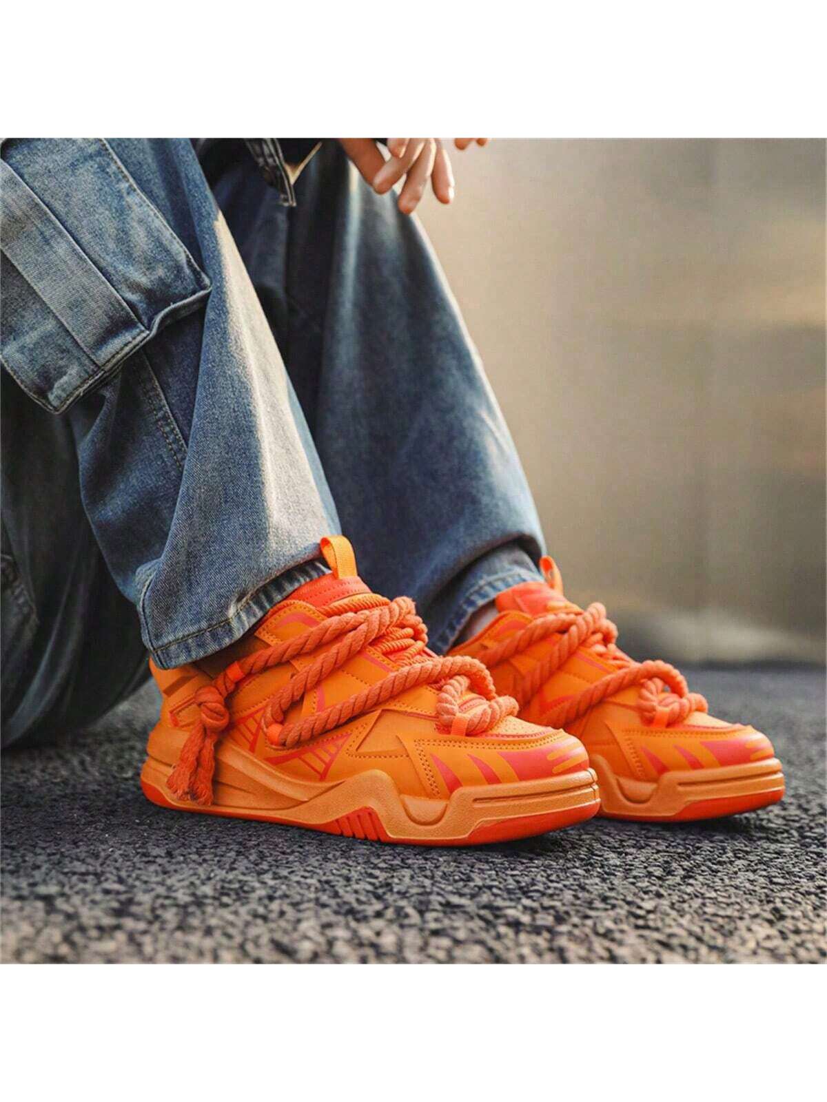 Chunky orange sneakers with thick rope laces, futuristic streetwear platform shoes