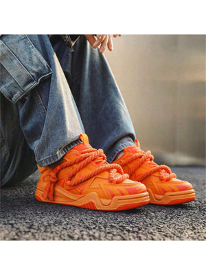 Chunky orange sneakers with thick rope laces, futuristic streetwear platform shoes