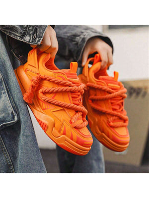 Chunky orange sneakers with thick rope laces, futuristic streetwear platform shoes
