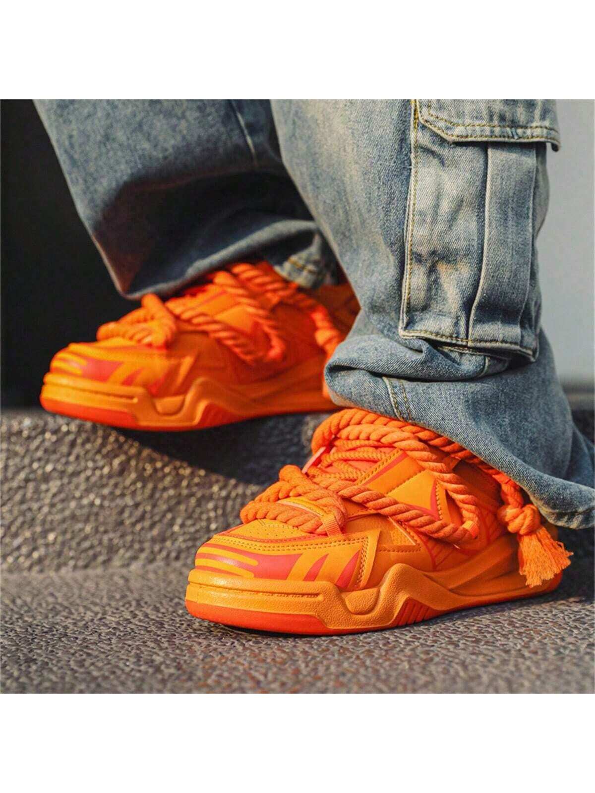 Chunky orange sneakers with thick rope laces, futuristic streetwear platform shoes