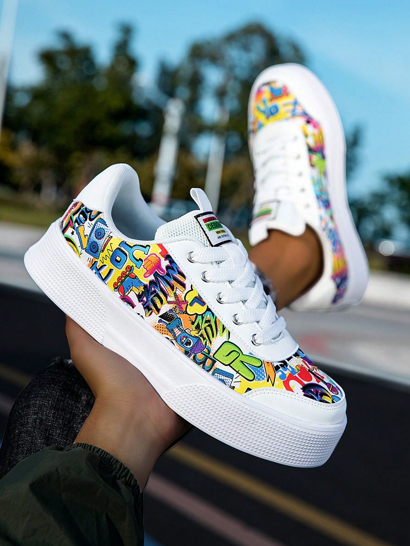 Colorful graffiti street sneakers with white base and comic-style print, lace-up low tops with EVA sole