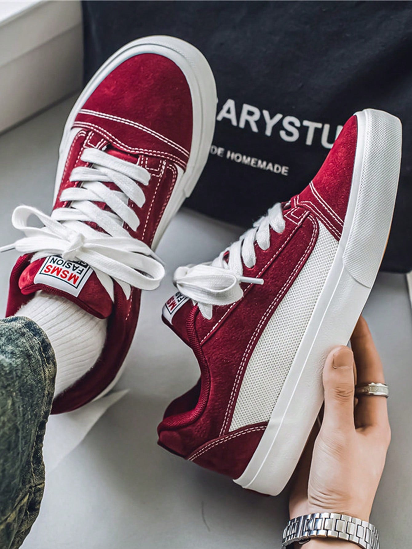 Burgundy and white low-top sneakers with lace-up closure, mesh upper, and flat rubber outsole, modern streetwear shoes