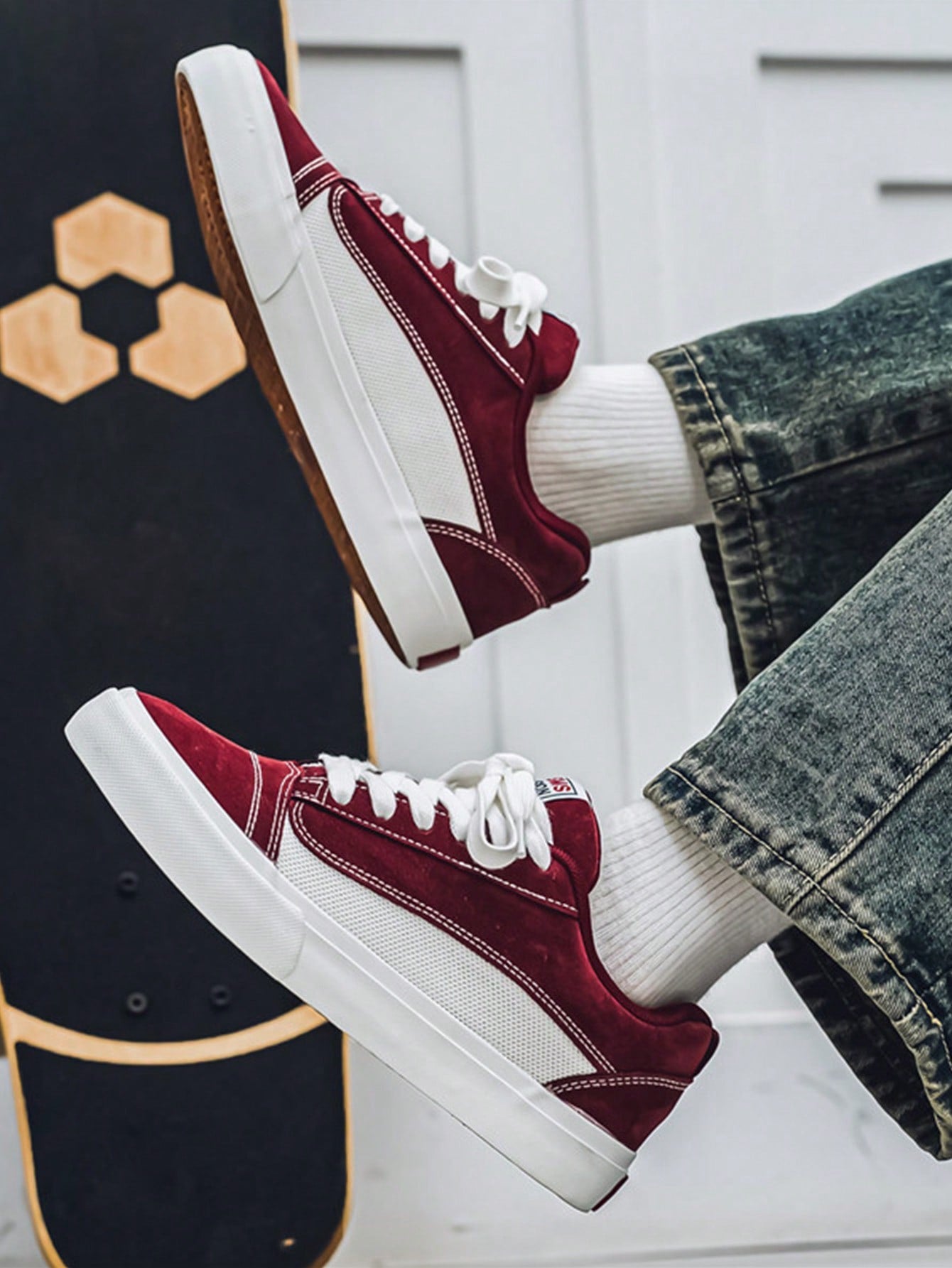 Burgundy and white low-top sneakers with lace-up closure, mesh upper, and flat rubber outsole, modern streetwear shoes