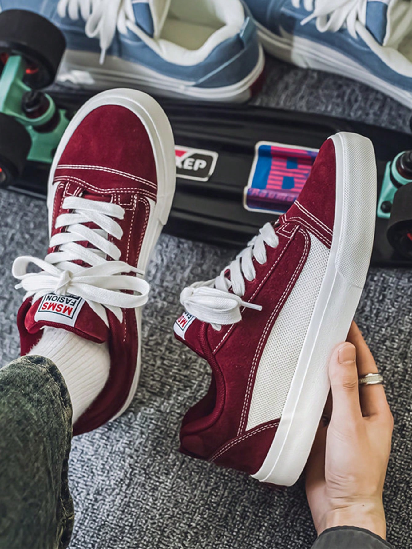 Burgundy and white low-top sneakers with lace-up closure, mesh upper, and flat rubber outsole, modern streetwear shoes