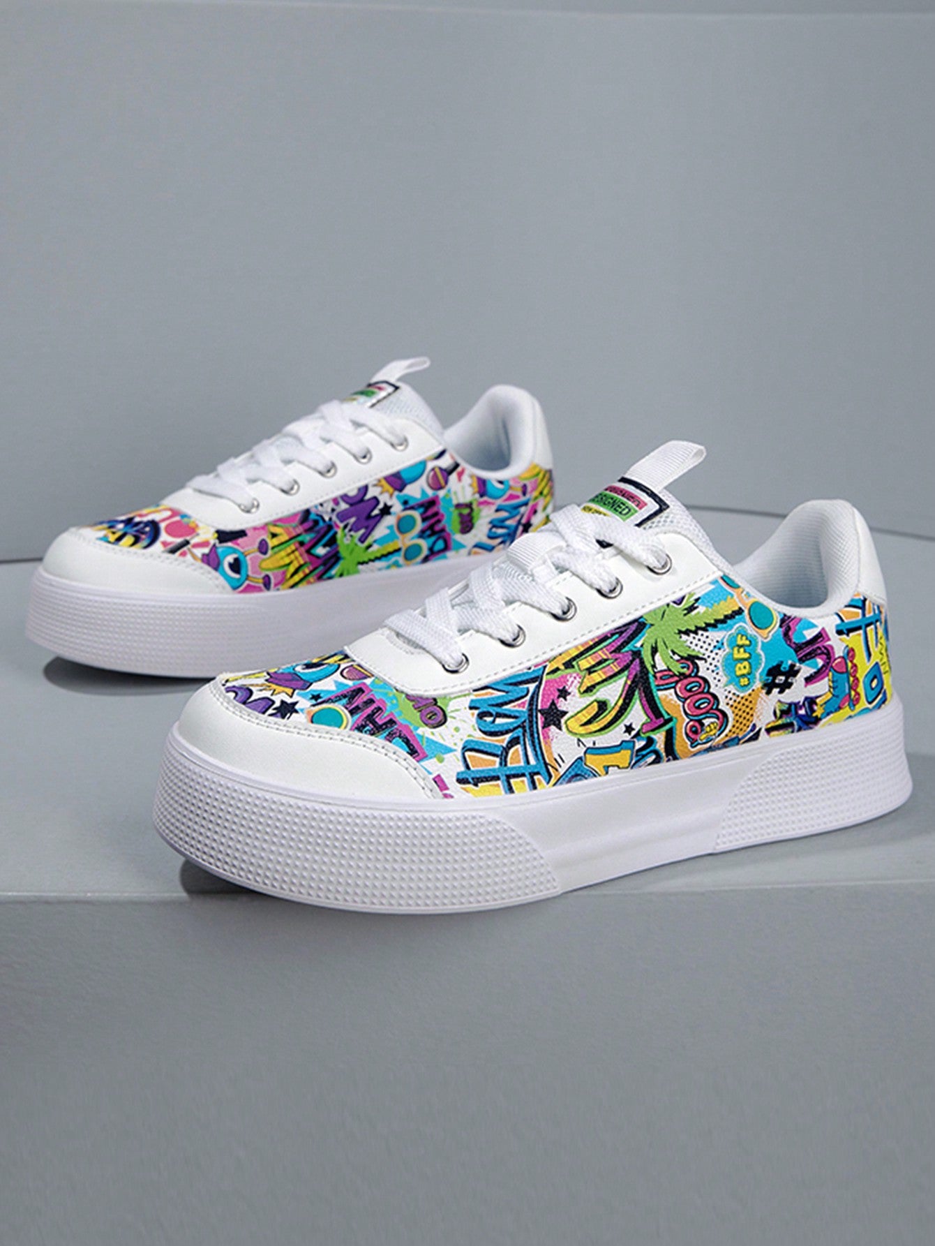 Colorful graffiti street sneakers with white base and comic-style print, lace-up low tops with EVA sole