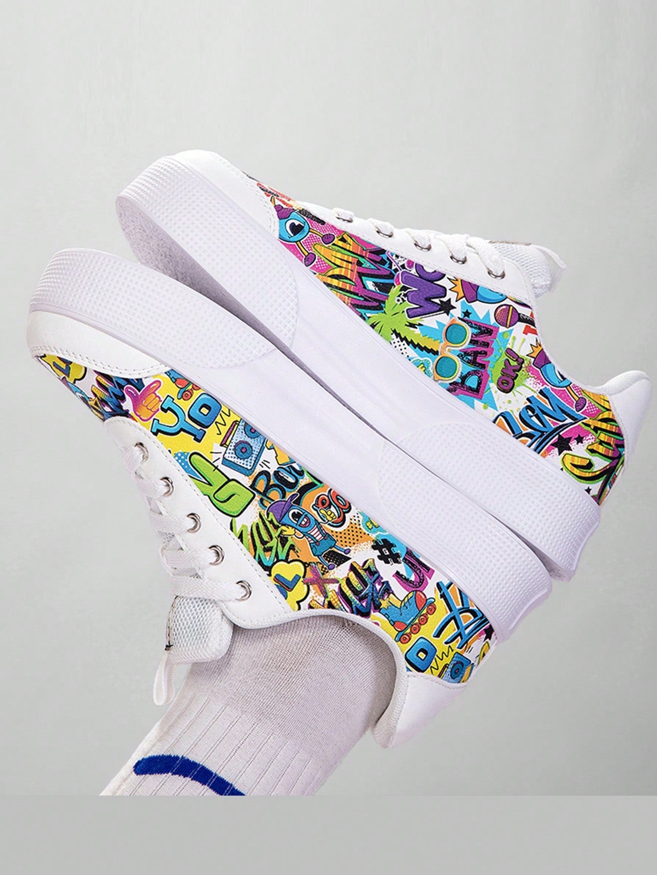 Colorful graffiti street sneakers with white base and comic-style print, lace-up low tops with EVA sole