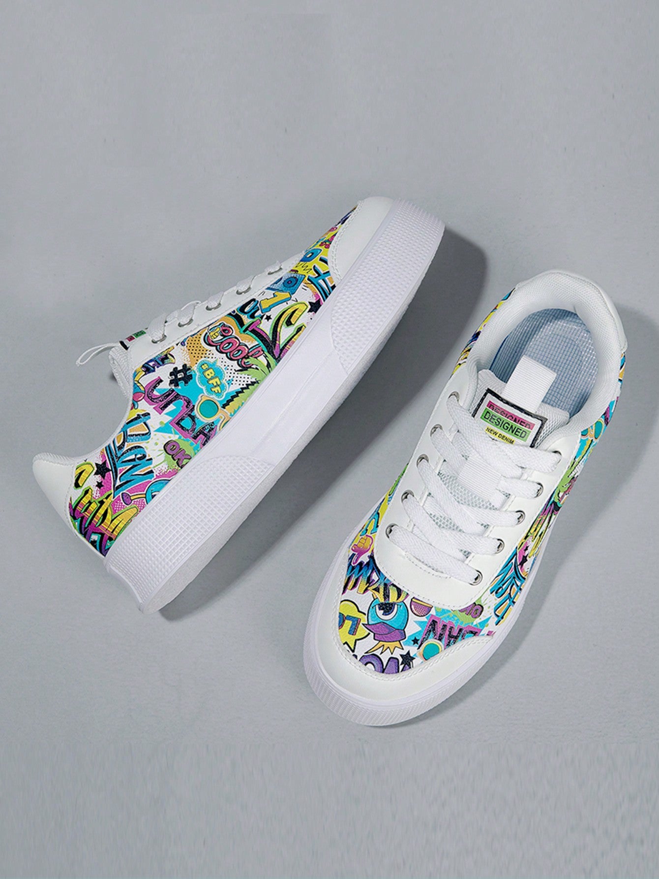 Colorful graffiti street sneakers with white base and comic-style print, lace-up low tops with EVA sole