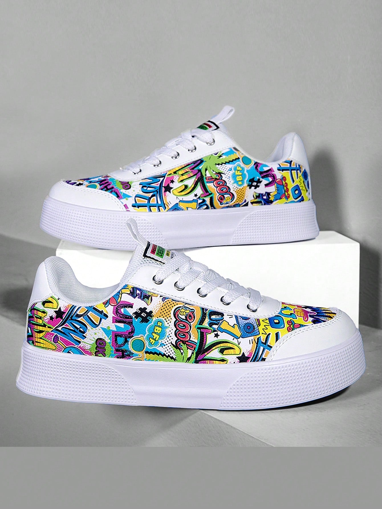 Colorful graffiti street sneakers with white base and comic-style print, lace-up low tops with EVA sole