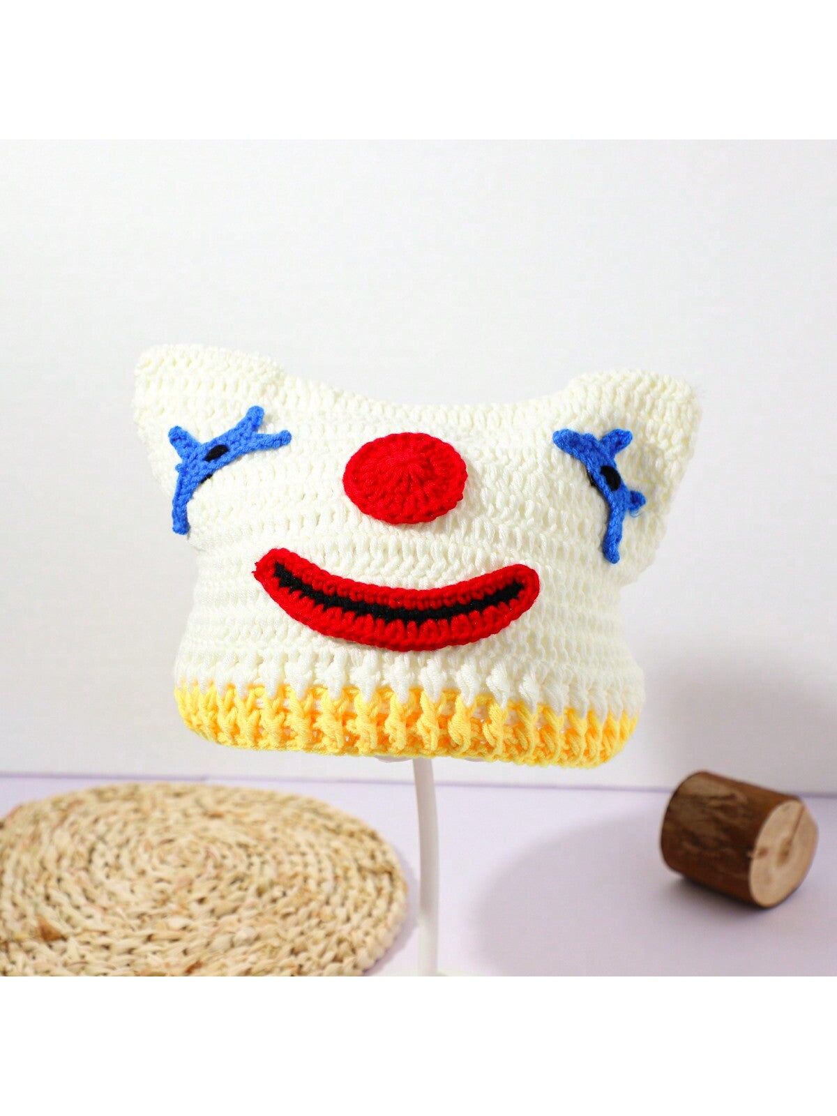 Hand-crocheted clown face beanie for women with red nose and blue stitched eyes, Halloween streetwear knit hat