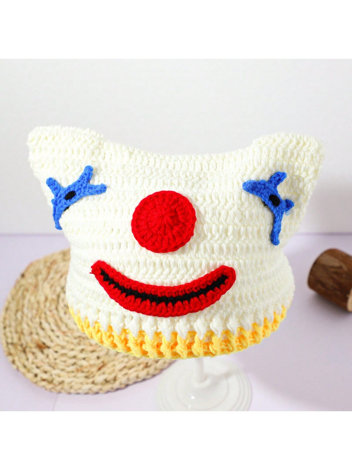 Hand-crocheted clown face beanie for women with red nose and blue stitched eyes, Halloween streetwear knit hat