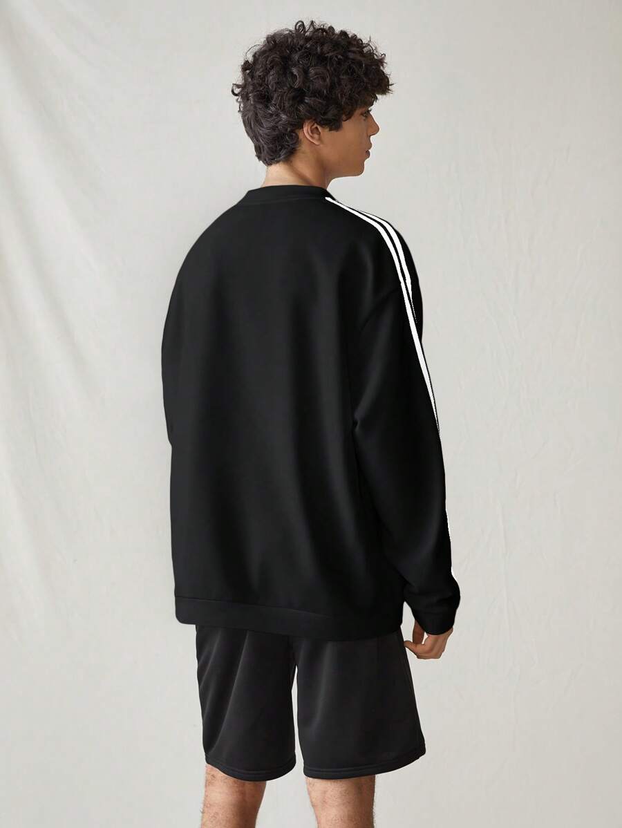 Japanese streetwear black pullover sweatshirt with white side stripes, loose fit, and embroidered chest detail
