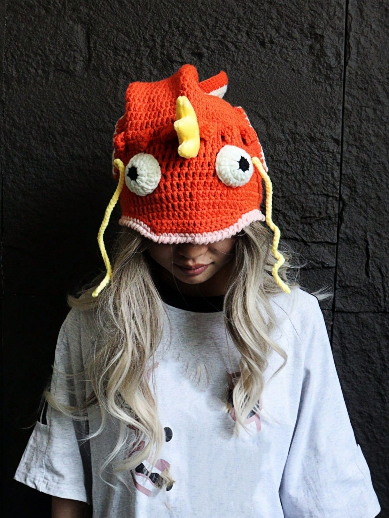 Orange crocheted fish hat with large fins, cartoon eyes, and crown, Magikarp-inspired kawaii streetwear beanie for women
