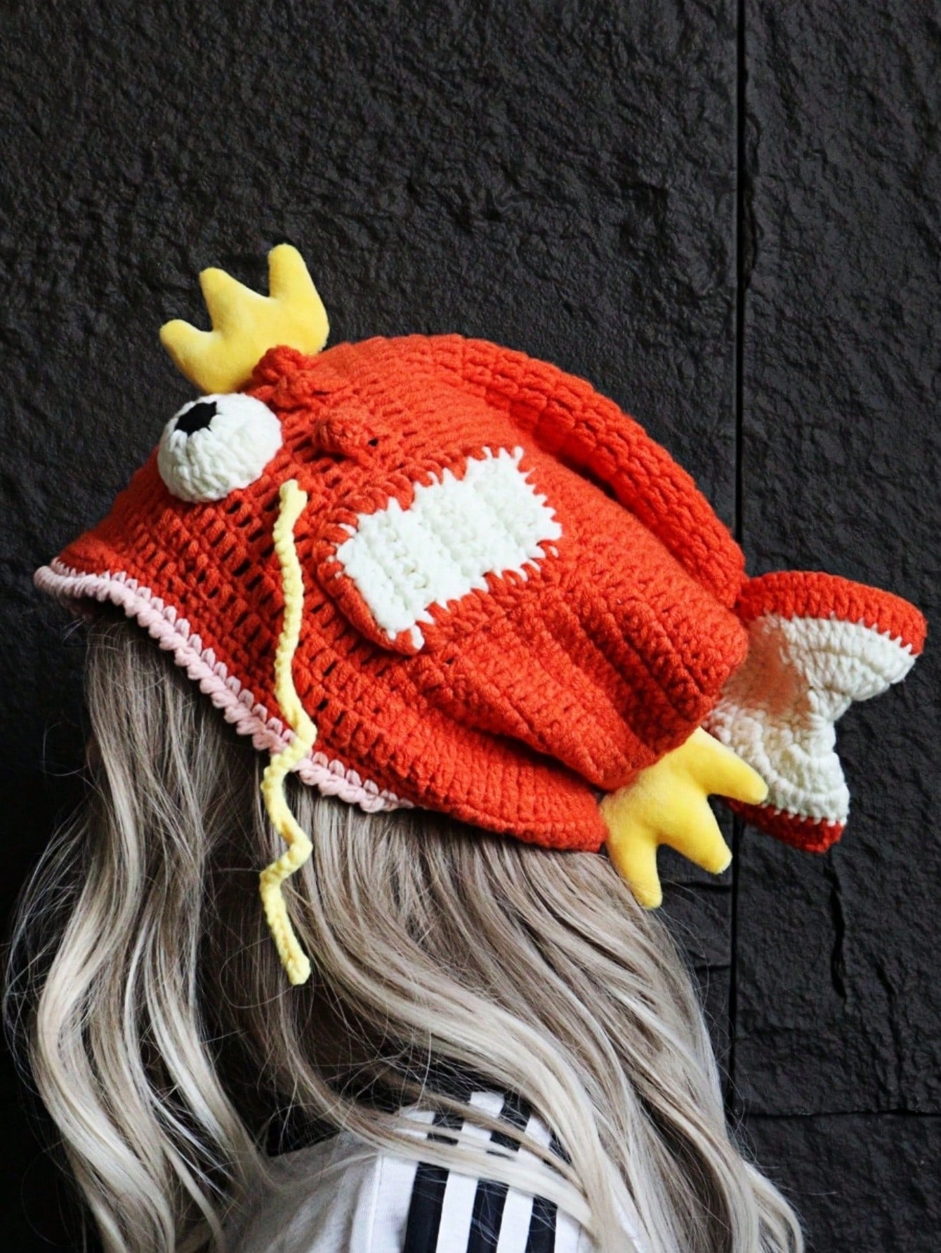 Orange crocheted fish hat with large fins, cartoon eyes, and crown, Magikarp-inspired kawaii streetwear beanie for women