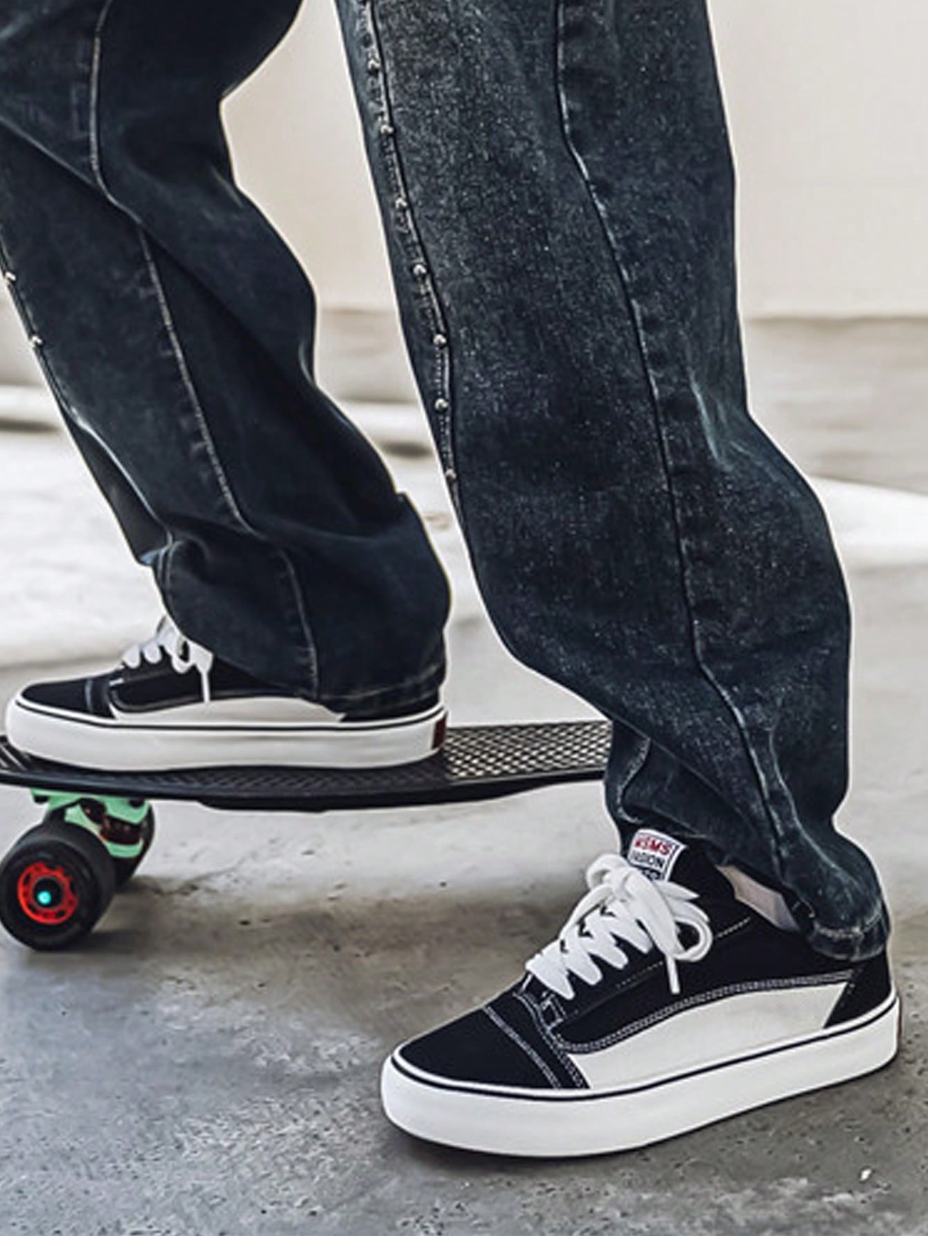 Black and white low-top sneakers with lace-up closure, mesh upper, and flat rubber outsole, modern streetwear shoes