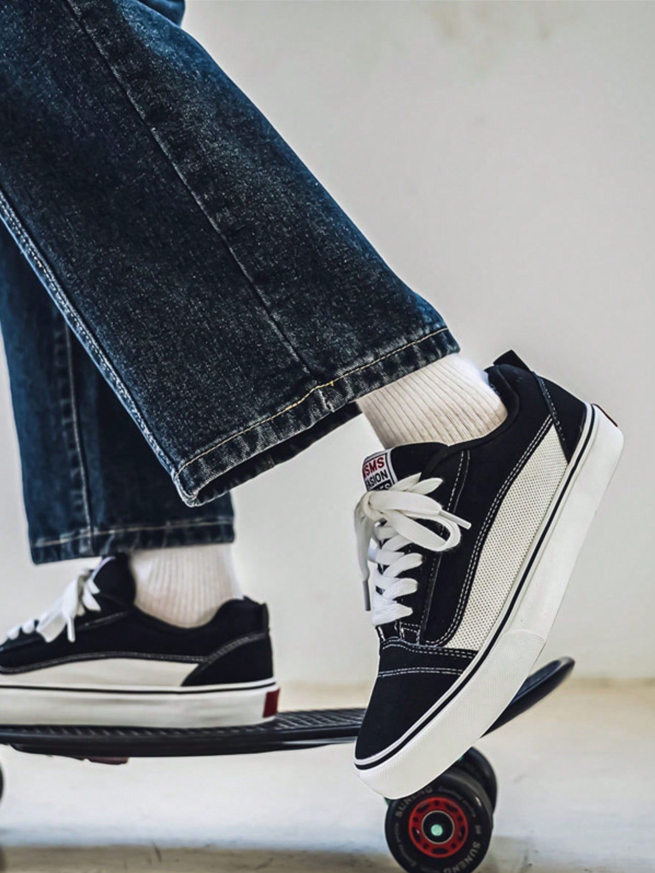 Black and white low-top sneakers with lace-up closure, mesh upper, and flat rubber outsole, modern streetwear shoes
