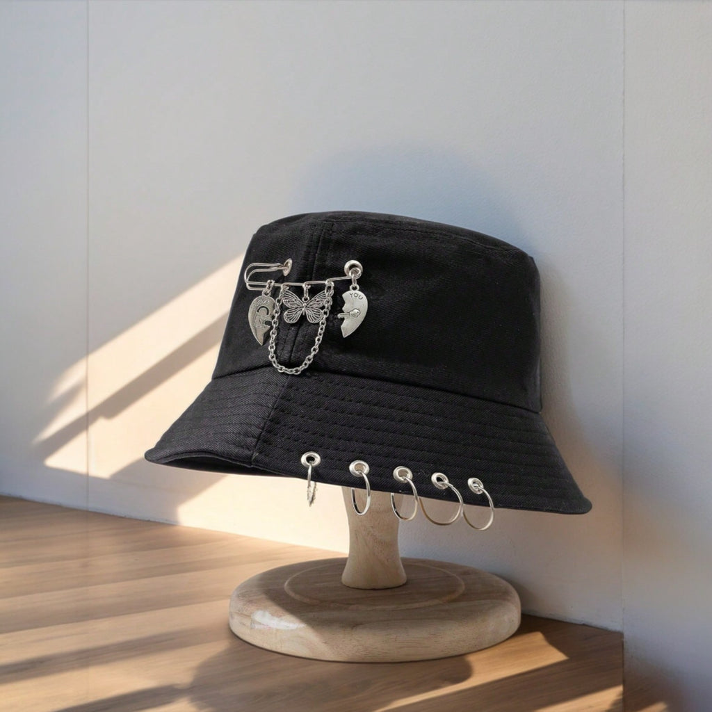 Black bucket hat with safety pin charms and silver piercing rings, butterfly and heart detail, cotton gothic Y2K streetwear cap

